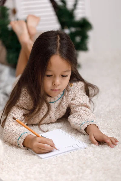 Söta barn flicka skriva brev till jultomten hemma — Stockfoto