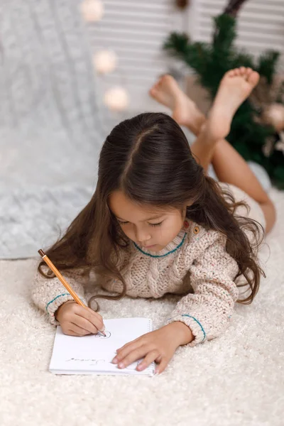 Linda niña escribiendo carta a Santa Claus en casa —  Fotos de Stock