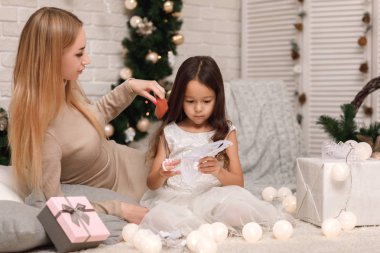 Anne ile kız çocuk dekorasyon Noel ağacı için kağıt kar taneleri yapar