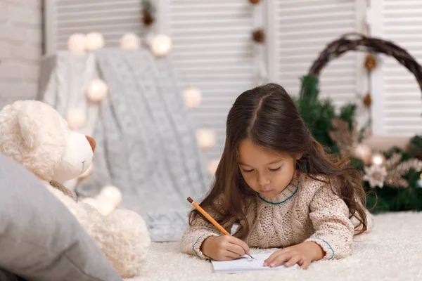 Söta barn flicka skriva brev till jultomten hemma — Stockfoto