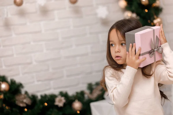 Ganska leende flicka håller julklapp i handen — Stockfoto