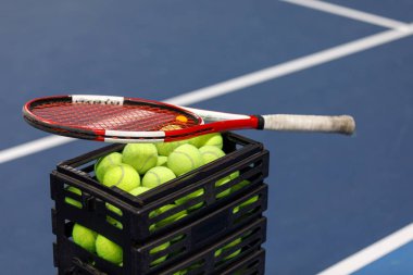 Tenis topları ve tenis kortunda tenis raketi ile kutu