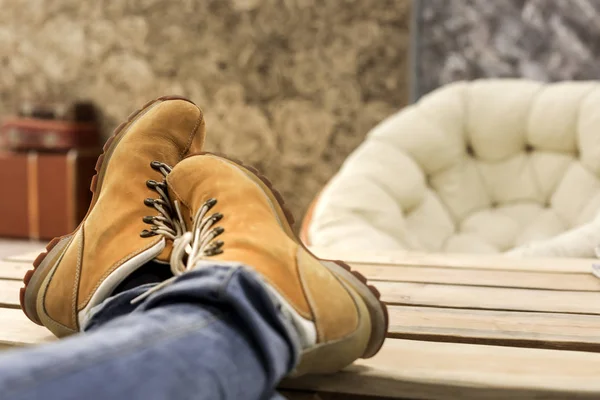 Mężczyzna nogi buty pomarańczowy relaksujący na drewnianym stole — Zdjęcie stockowe
