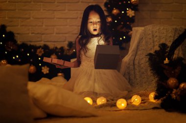 Çok gülümseyen kız Noel hediyesi elinde tutan