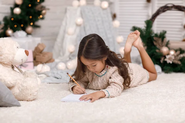 Söta barn flicka skriva brev till jultomten hemma — Stockfoto