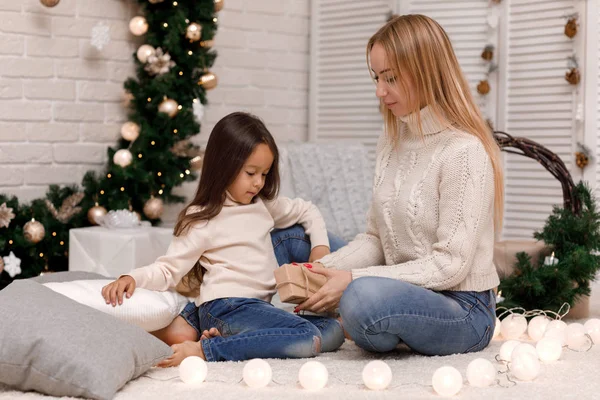 Mother and child girl pack Christmas gifts at home. — Stock Photo, Image