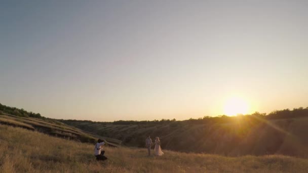 Bröllopsfotograf Tar Bilder Bruden Och Brudgummen Naturen Vid Solnedgången Fotograf — Stockvideo