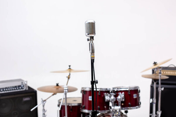 Microphone in a recording studio with drum on background.