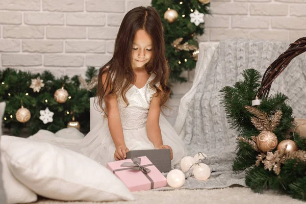 Досить усміхнена дівчина тримає різдвяний подарунок в руці — стокове фото