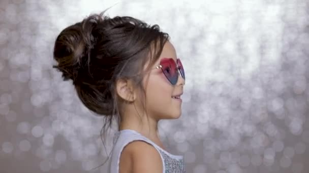 可爱快乐的小女孩在银色礼服跳舞的背景下的银 bokeh. — 图库视频影像