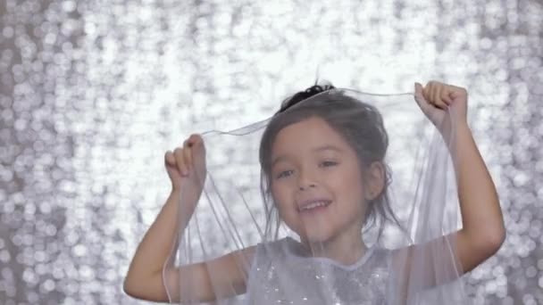 Ładny szczęśliwy małe dziecko dziewczynka w srebrny sukienka taniec na tle bokeh srebrny. — Wideo stockowe