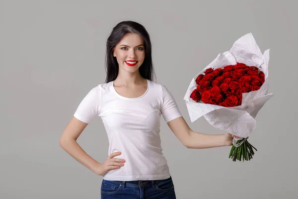 赤いバラの大きな花束と美しい若い女性 — ストック写真
