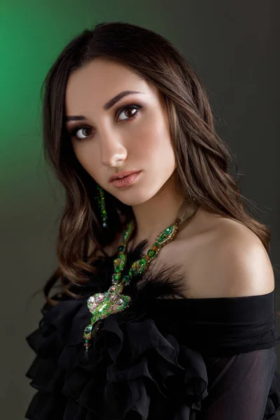 Beautiful woman with beautiful hair, makeup and with luxury necklace on dark green background. — Stock Photo, Image