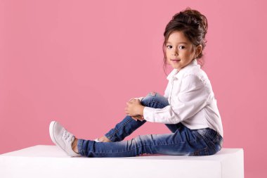 Sevimli gülümseyen küçük kız saç modeli ile beyaz gömlekli