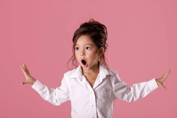 Schattig verrast klein meisje in wit overhemd met kapsel — Stockfoto