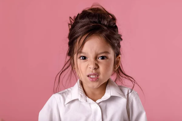 angry little child girl in white shirt with hairstyle