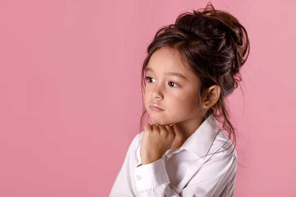 Vackra tveksamt, eftertänksam liten flicka i vit skjorta med frisyr — Stockfoto