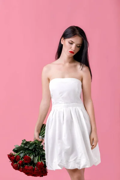 Beautiful young woman with a large bouquet of red roses — Stock Photo, Image