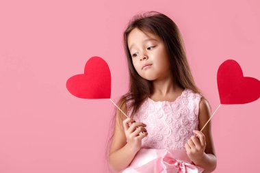 Kağıt kalp tutan bir pembe elbiseli sevimli küçük kız