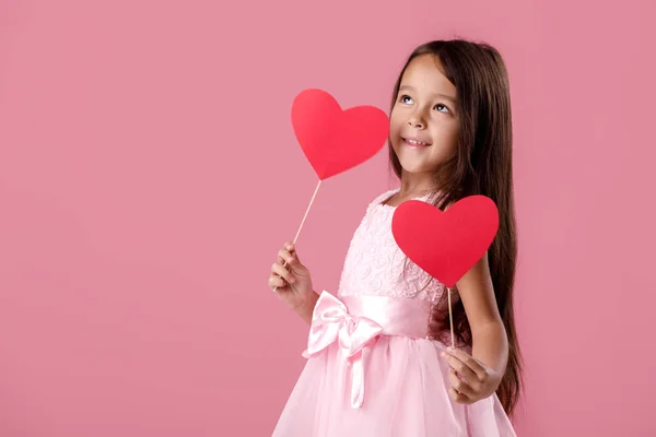 Mignonne petite fille dans une robe rose tenant un coeur en papier — Photo