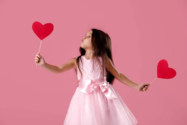 Schattig klein meisje in een roze jurk houden een papier-hart — Stockfoto