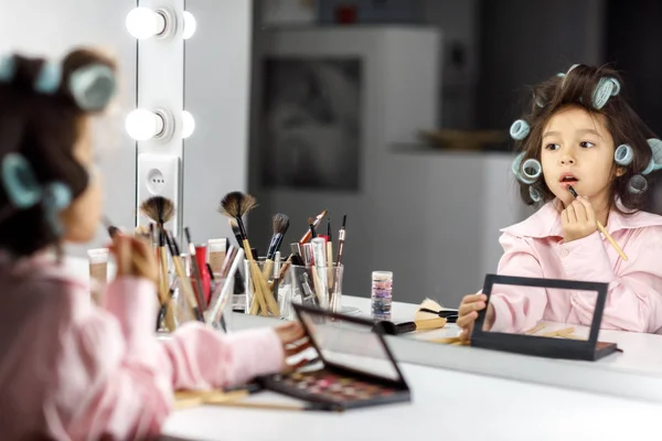 Niedliches kleines Mädchen spielt mit ihren Müttern Kosmetik — Stockfoto