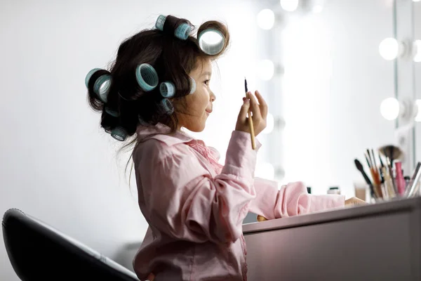 Cute little girl playing with her mothers cosmetic — Stock Photo, Image
