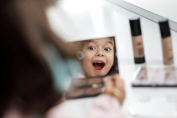 Niedliches kleines Mädchen spielt mit ihren Müttern Kosmetik — Stockfoto