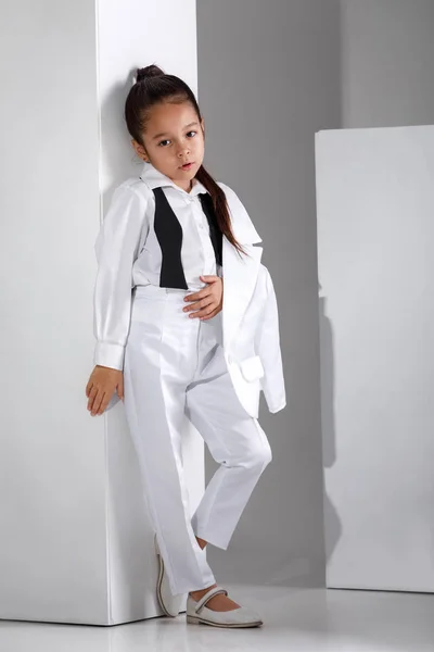 Modelo de niña de moda en un traje blanco y pajarita —  Fotos de Stock