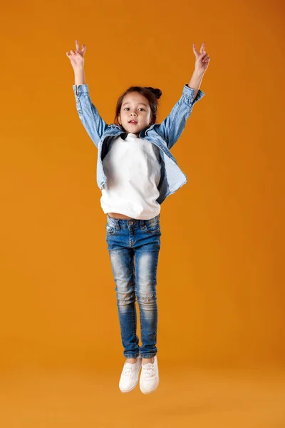 Heureuse petite fille enfant en jeans vêtements sautant — Photo