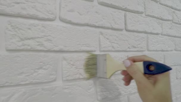 Trabajador barnices manualmente ladrillo decorativo en la pared . — Vídeo de stock