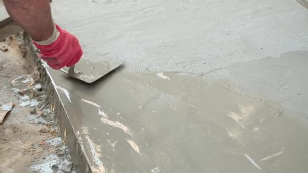 Pracownik budowlany, wygładzając świeżo wylany beton. — Wideo stockowe