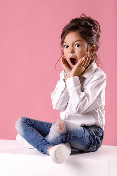 Carino sorpreso bambina in camicia bianca con acconciatura — Foto Stock