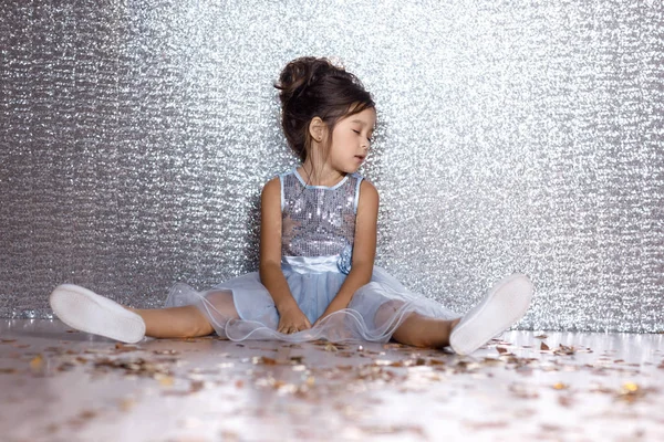 Klein kind meisje in jurk zittend op de vloer met confetti — Stockfoto