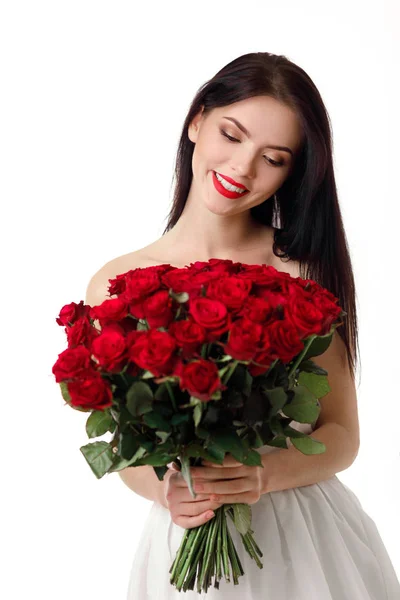 赤いバラの大きな花束と美しい若い女性 — ストック写真