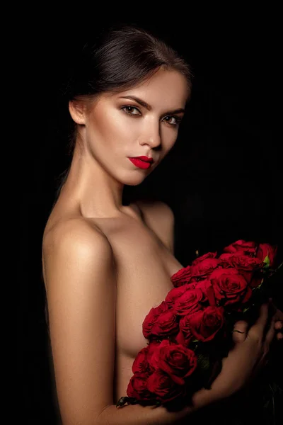 Femeie tânără frumoasă cu un buchet mare de trandafiri roșii — Fotografie, imagine de stoc