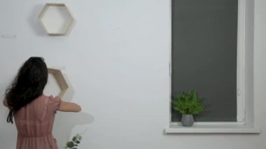 kadın ahşap raflar asmak ve dekor raflarda koyar