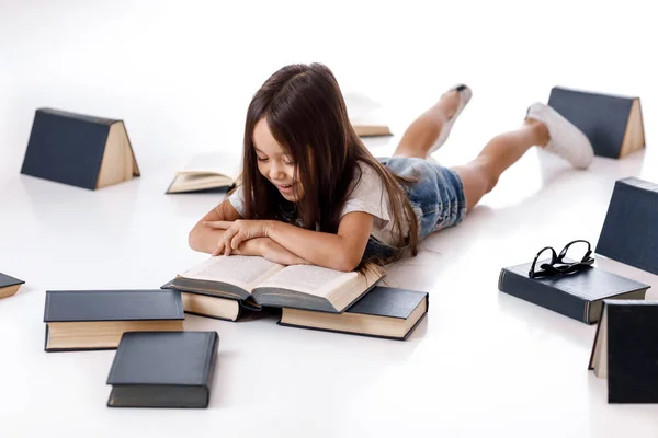 Menina bonito está lendo um livro . — Fotografia de Stock