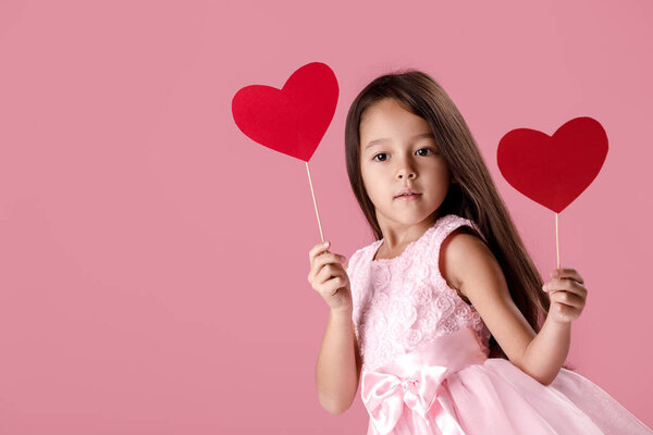 cute little girl in a pink dress holding a paper heart