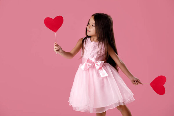 cute little girl in a pink dress holding a paper heart