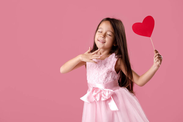 cute little girl in a pink dress holding a paper heart