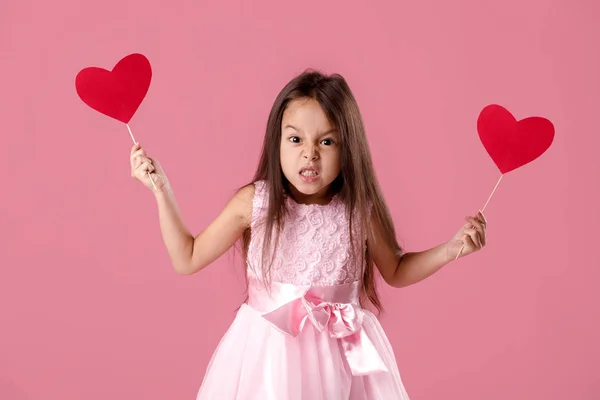 Mignonne petite fille dans une robe rose tenant un coeur en papier — Photo