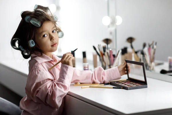 Niedliches kleines Mädchen spielt mit ihren Müttern Kosmetik — Stockfoto
