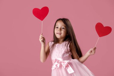 Kağıt kalp tutan bir pembe elbiseli sevimli küçük kız