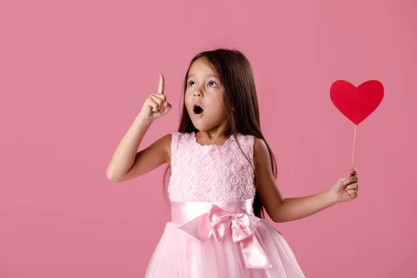 Menina bonito em um vestido rosa segurando um coração de papel — Fotografia de Stock