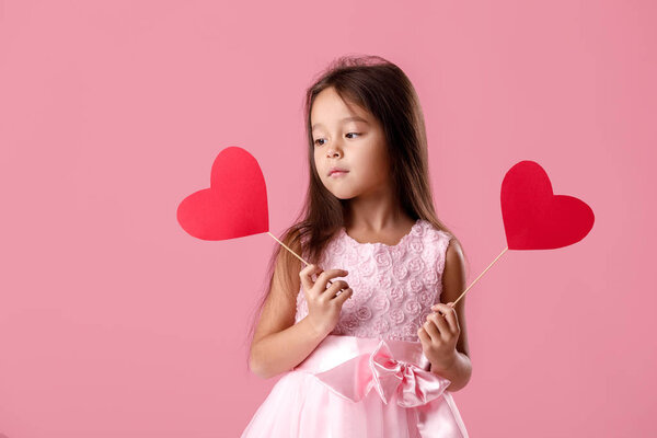 cute little girl in a pink dress holding a paper heart