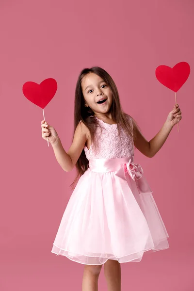 Schattig klein meisje in een roze jurk houden een papier-hart — Stockfoto