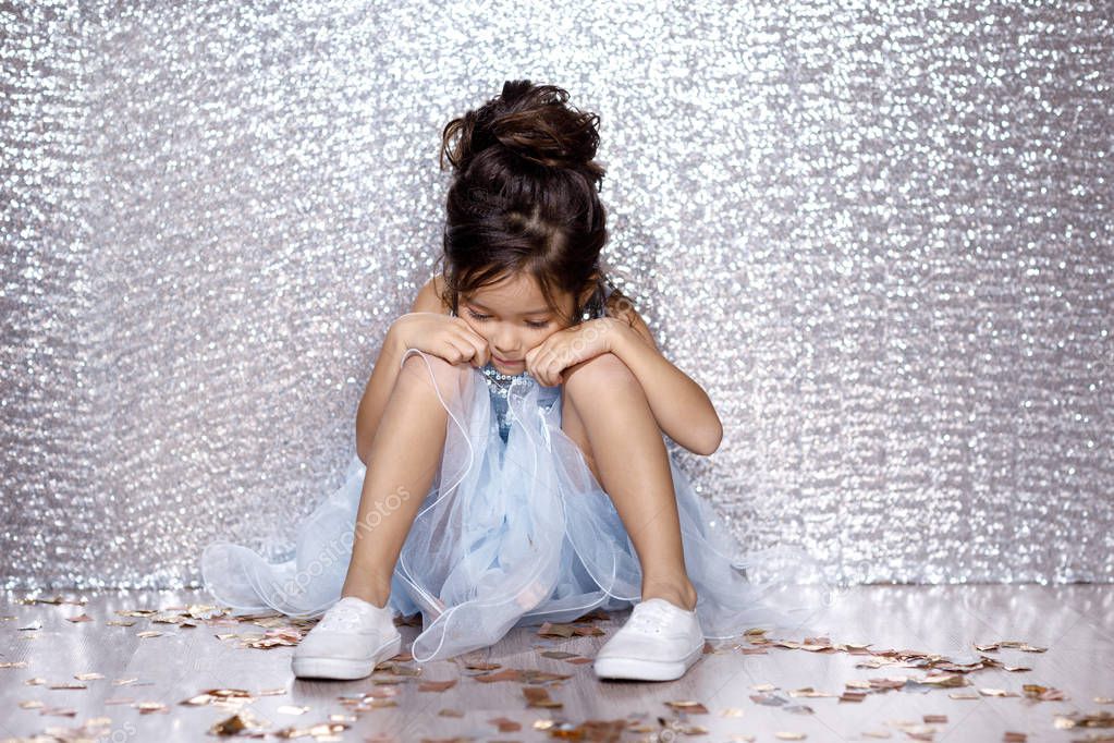 little child girl in dress sitting on the floor with confetti