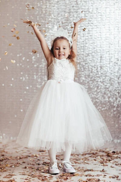 Niña pequeña en vestido de princesa sobre fondo confeti —  Fotos de Stock