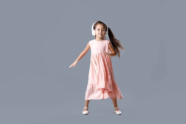 Niña en vestido y auriculares escucha música y bailes —  Fotos de Stock